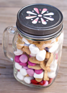 A jar with marshmallows and pink candy