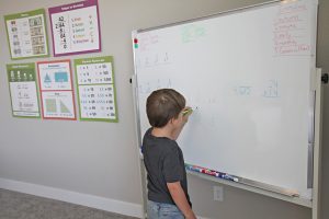 A boy writing on a whiteboard