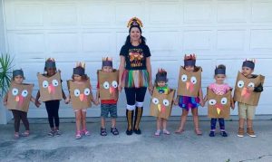 Ms. Aurica with kids in a costume