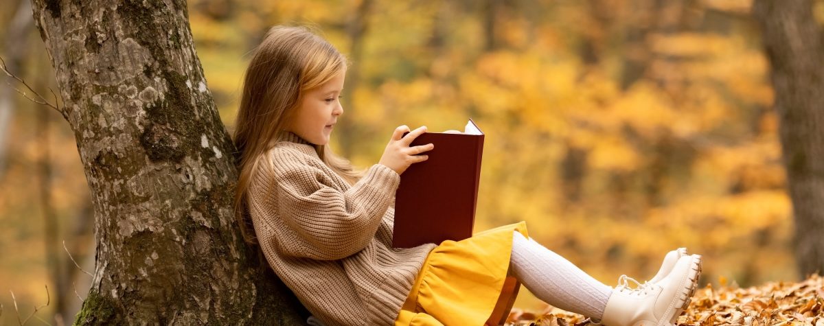Cute,Little,Girl,With,Blonde,Hair,Sitting,Under,The,Tree