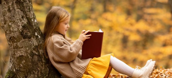 Cute,Little,Girl,With,Blonde,Hair,Sitting,Under,The,Tree