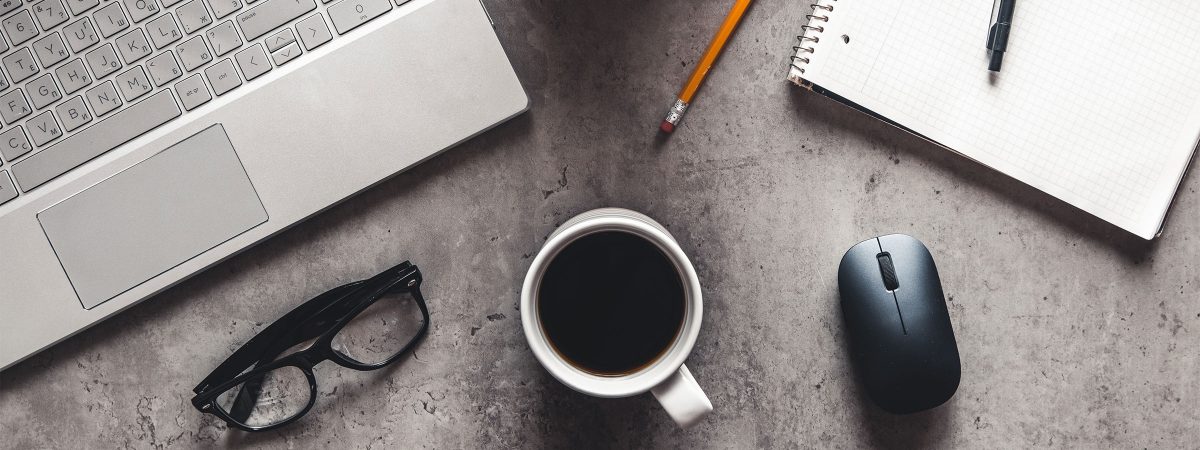 desk-with-laptop-glasses-coffee-cup-pencil-copmuter-mouse-and-notepad-on-it
