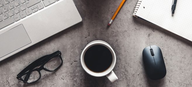 desk-with-laptop-glasses-coffee-cup-pencil-copmuter-mouse-and-notepad-on-it