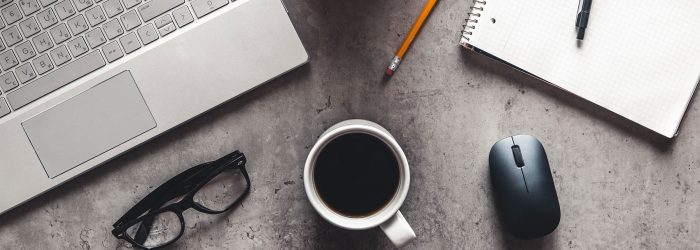desk-with-laptop-glasses-coffee-cup-pencil-copmuter-mouse-and-notepad-on-it
